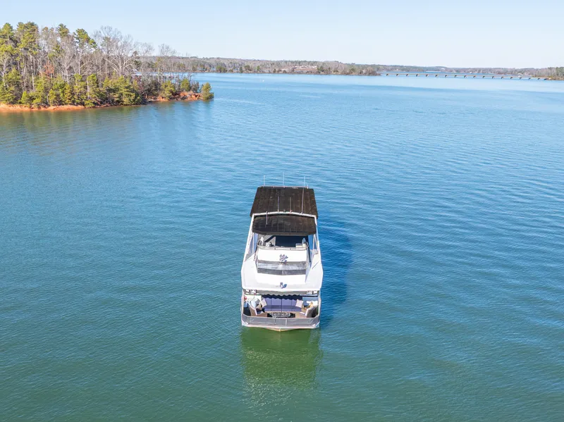 Slide: The Image of 1998 Stardust Cruisers Custom Luxury Houseboat on serene lake with clear blue water. - 3