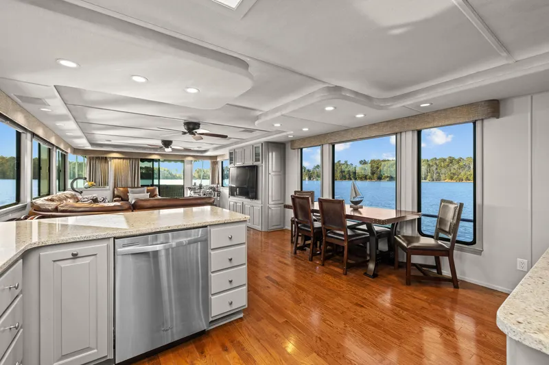 Slide: The Image of Luxurious 1998 Stardust Cruisers houseboat interior with modern kitchen and dining area, overlooking serene lake. - 35