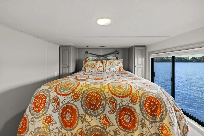 Slide: The Image of Luxurious bedroom in 1998 Stardust Cruisers houseboat with vibrant bedding and scenic water view. - 38