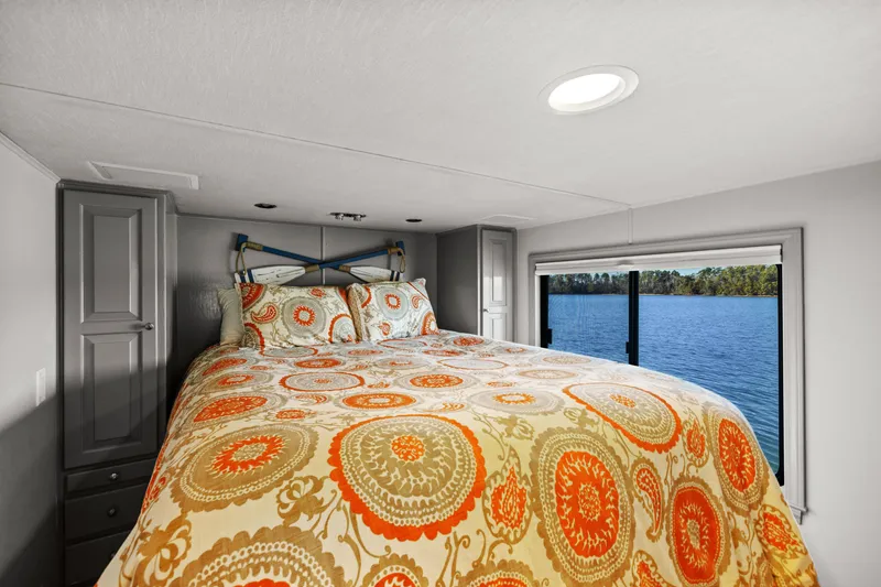 Slide: The Image of Luxurious bedroom in 1998 Stardust Cruisers houseboat with vibrant bedding and scenic water view. - 39