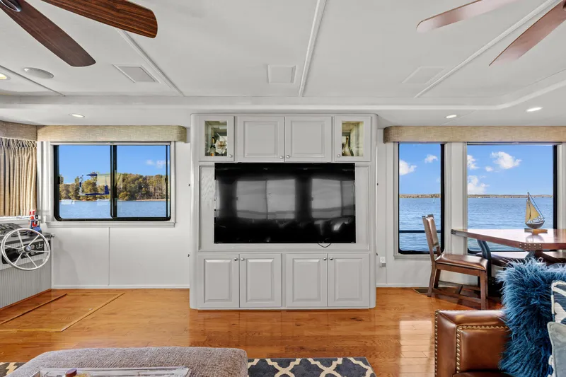 Slide: The Image of Luxurious 1998 Stardust Cruisers houseboat interior with lake view, featuring modern entertainment center. - 46