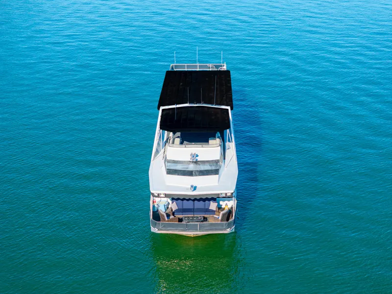 Slide: The Image of 1998 Stardust Cruisers Custom Luxury Houseboat on clear blue water, aerial view. - 6