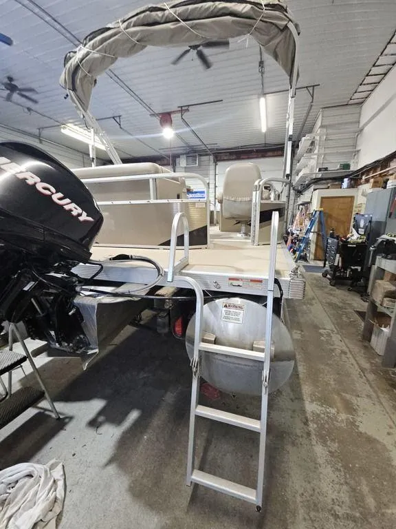 Slide: The Image of 2012 Bennington 20SL pontoon boat in a garage with Mercury outboard motor. - 5