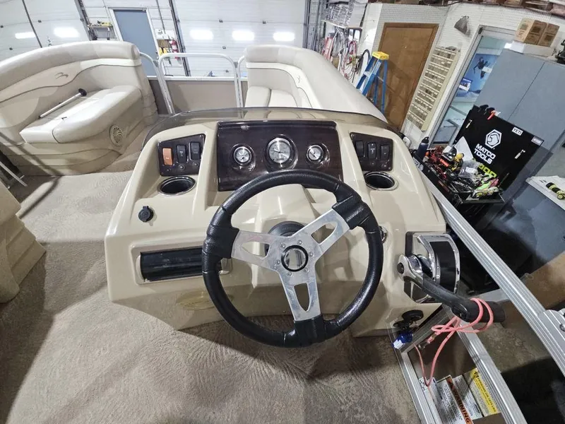 Slide: The Image of 2012 Bennington 20SL boat dashboard with steering wheel and control panel in a garage setting. - 7