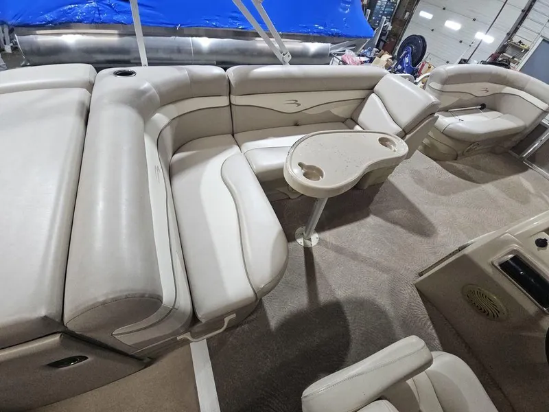Slide: The Image of 2012 Bennington 20SL pontoon boat interior with beige seating and cup holders. - 9
