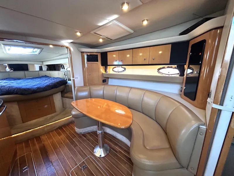 Slide: The Image of 2006 Chaparral Signature 350 yacht interior with curved seating, wooden table, and cozy cabin. - 11