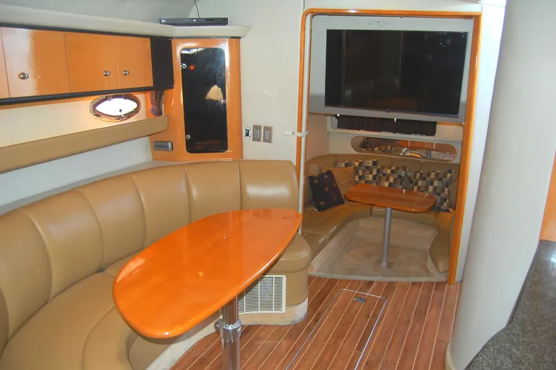 Slide: The Image of 2006 Chaparral Signature 350 interior with leather seating, wooden table, and mounted TV. - 17