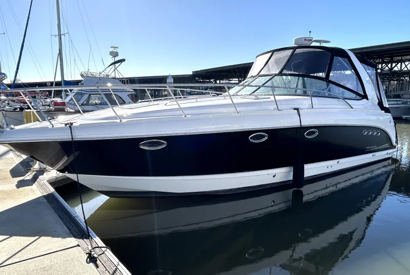 The Image of 2006 Chaparral Signature 350 boat docked in marina, sleek design, black and white exterior. - 2