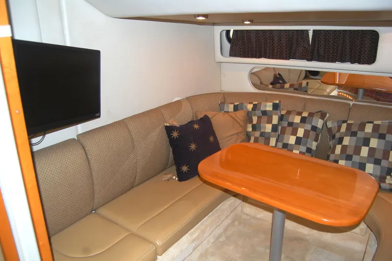 Slide: The Image of 2006 Chaparral Signature 350 interior with cozy seating, cushions, and a mounted TV. - 22