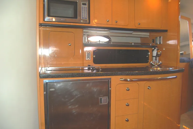 Slide: The Image of 2006 Chaparral Signature 350 yacht kitchen with microwave, cabinets, and stainless steel appliances. - 26