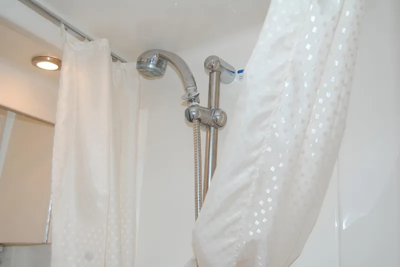 Slide: The Image of Shower area in 2006 Chaparral Signature 350 boat with white curtain and chrome fixtures. - 32