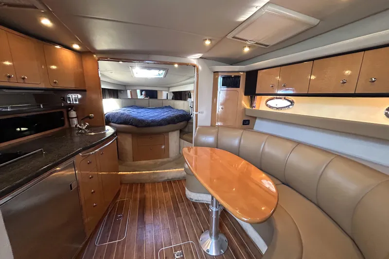 Slide: The Image of 2006 Chaparral Signature 350 interior with kitchen, dining area, and cozy sleeping quarters. - 6