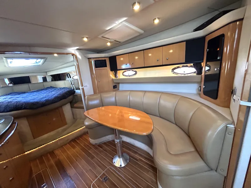 Slide: The Image of 2006 Chaparral Signature 350 interior with leather seating, wooden table, and cozy cabin layout. - 8