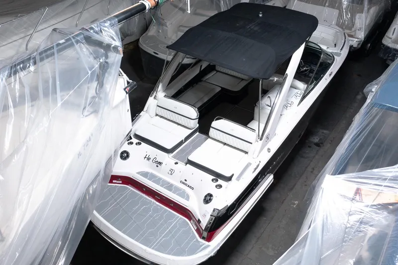 Slide: The Image of 2021 Regal 2800 Bowrider boat with black canopy in storage. - 15