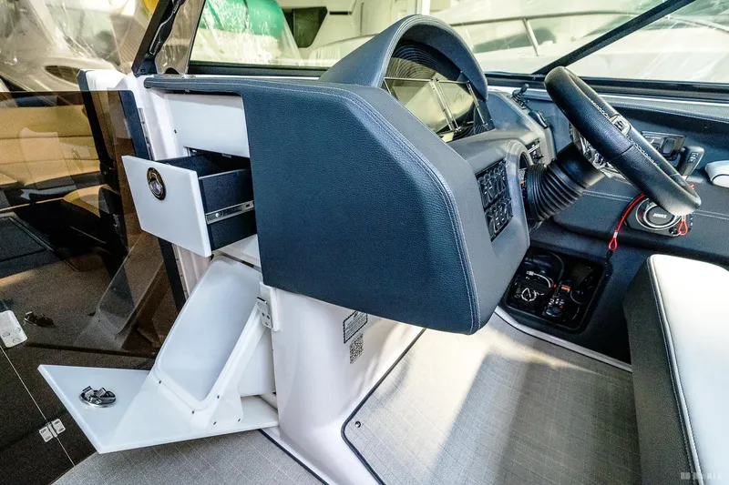 Slide: The Image of 2021 Regal 2800 Bowrider helm with steering wheel and storage compartments. - 24
