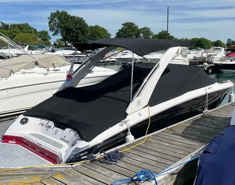 Slide: The Image of 2021 Regal 2800 Bowrider boat docked with black canopy cover. - 3