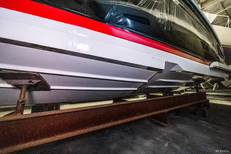 Slide: The Image of 2021 Regal 2800 Bowrider boat hull on a metal stand in storage. - 49