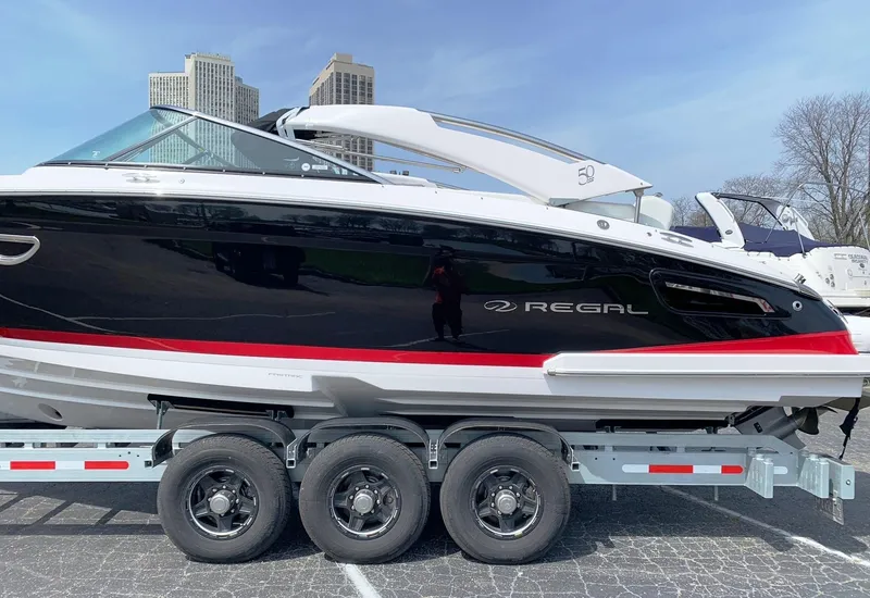 Slide: The Image of 2021 Regal 2800 Bowrider boat on trailer, black and white with red stripe. - 55