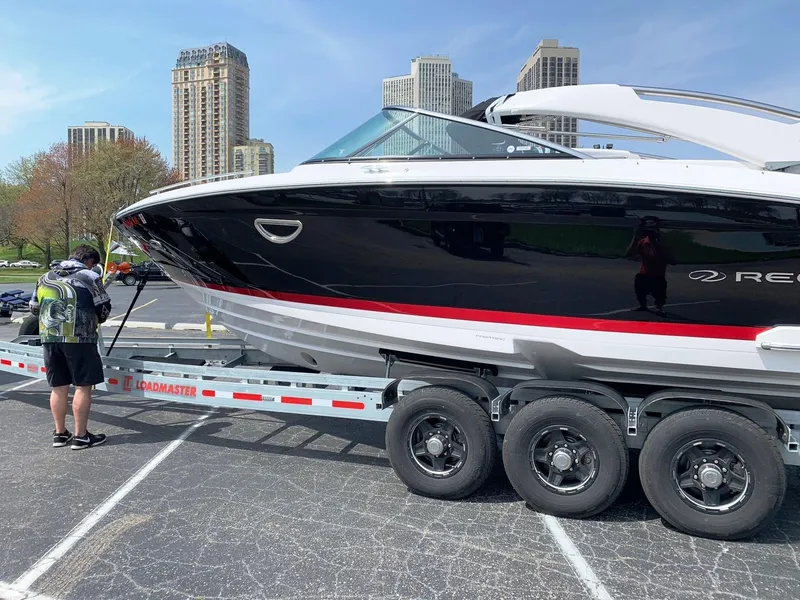 Slide: The Image of 2021 Regal 2800 Bowrider on trailer in urban setting, skyscrapers in background. - 56