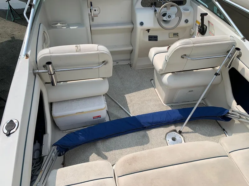Slide: The Image of Interior of a 2000 Sea Ray 215 Express Cruiser with white seating and steering wheel. - 6