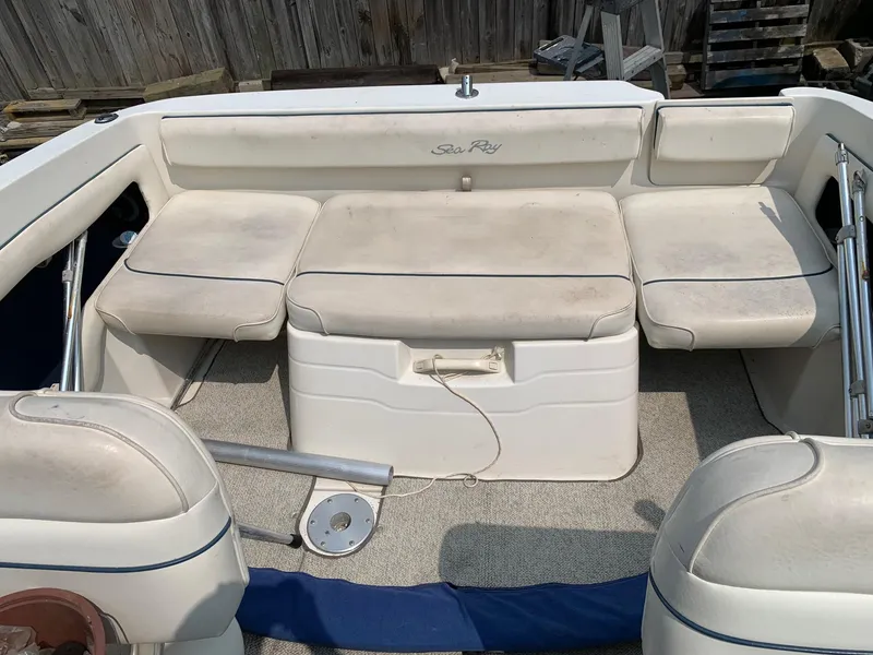 Slide: The Image of 2000 Sea Ray 215 Express Cruiser interior with cushioned seating and storage. - 8