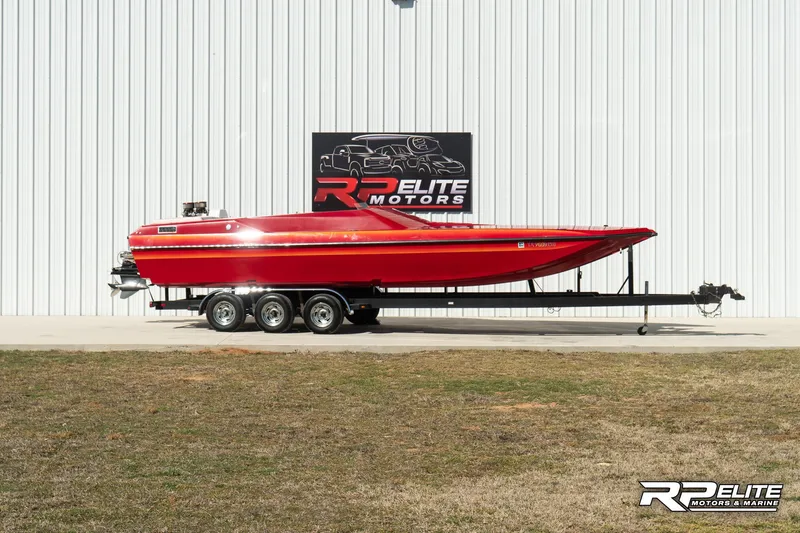 Slide: The Image of Red 1998 Warlock 28 SXT boat on trailer at RP Elite Motors. - 0