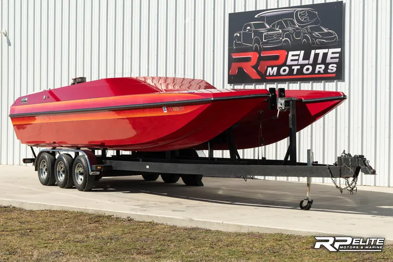 Slide: The Image of Red 1998 Warlock 28 SXT boat on trailer at RP Elite Motors. - 1