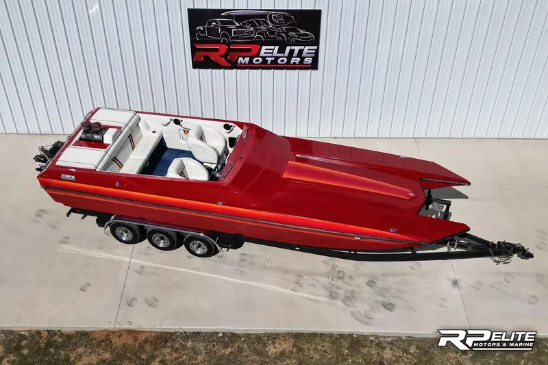 Slide: The Image of Red 1998 Warlock 28 SXT speedboat on trailer, parked at RP Elite Motors. - 12