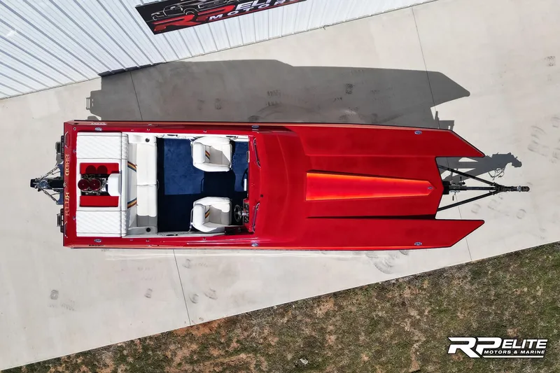 Slide: The Image of Overhead view of a red 1998 Warlock 28 SXT speedboat on concrete. - 15