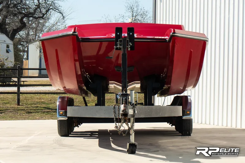 Slide: The Image of Red 1998 Warlock 28 SXT boat on trailer, parked outdoors. - 2