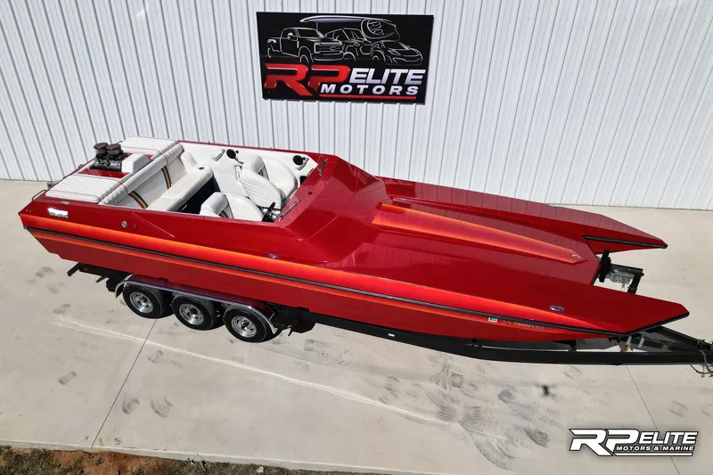 Slide: The Image of Red 1998 Warlock 28 SXT speedboat on trailer, displayed at RP Elite Motors. - 21