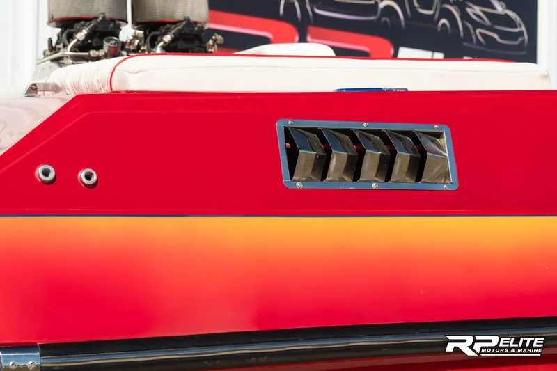 Slide: The Image of 1998 Warlock 28 SXT boat with vibrant red and orange detailing. - 23