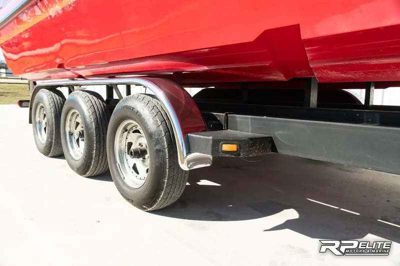 Slide: The Image of Red 1998 Warlock 28 SXT boat on a triple-axle trailer, side view. - 26