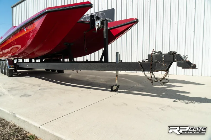 Slide: The Image of Red 1998 Warlock 28 SXT boat on trailer, parked outside a building. - 27
