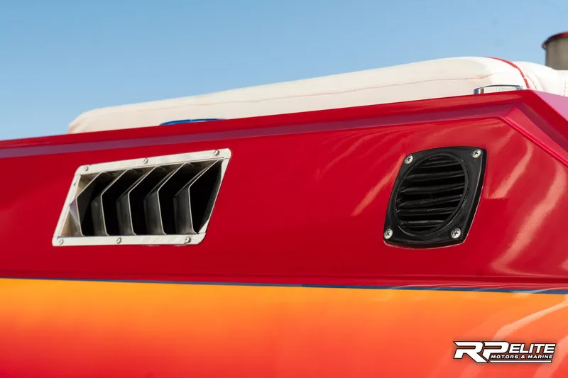 Slide: The Image of 1998 Warlock 28 SXT boat detail, featuring vibrant red and orange exterior with ventilation grilles. - 35