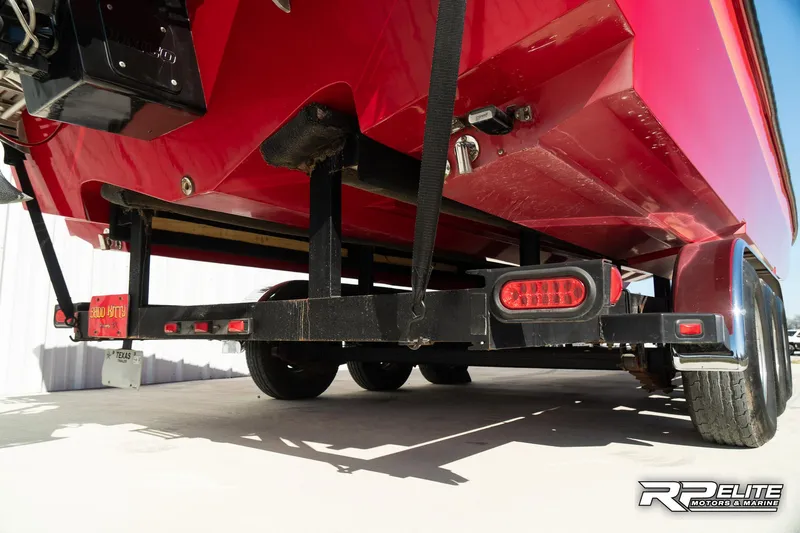 Slide: The Image of Underneath view of a red 1998 Warlock 28 SXT boat on a trailer. - 49