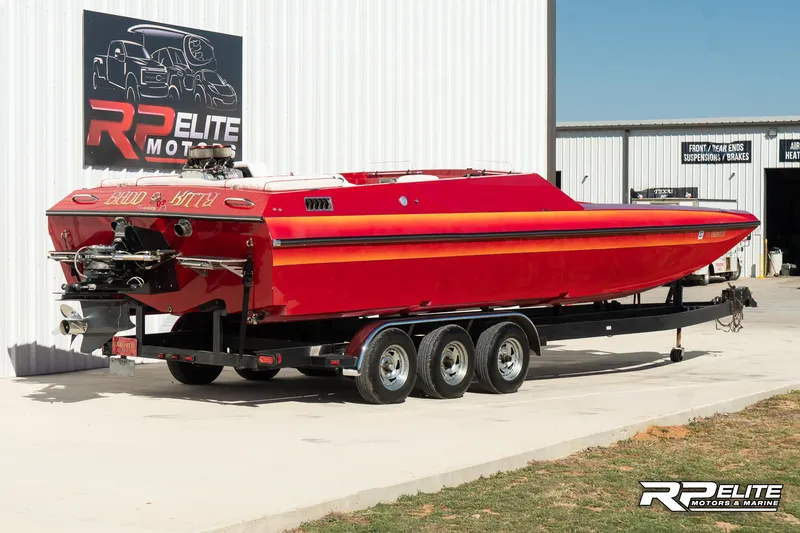 Slide: The Image of Red 1998 Warlock 28 SXT speedboat on trailer at RP Elite Motors & Marine. - 8