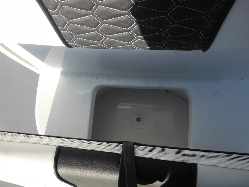Slide: The Image of 2025 Tidewater 232 LXF boat interior storage compartment with cushioned seating. - 22