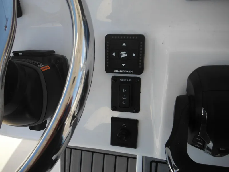 Slide: The Image of 2025 Tidewater 232 LXF boat dashboard with steering wheel and control panel. - 46