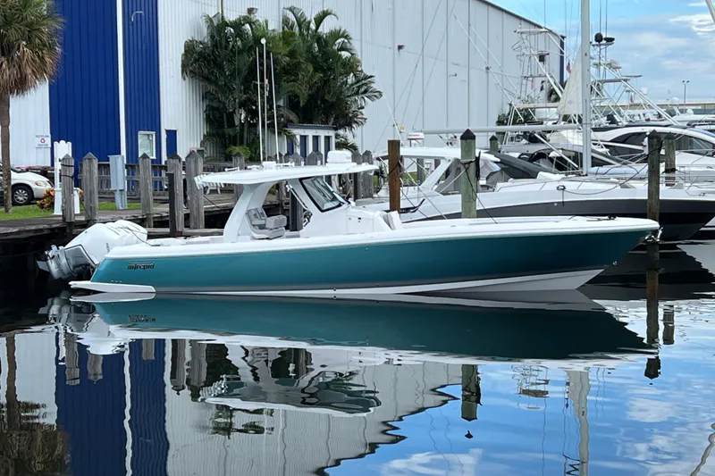 The Image of 2023 Intrepid 375 boat docked at marina, reflecting on calm water. - 0