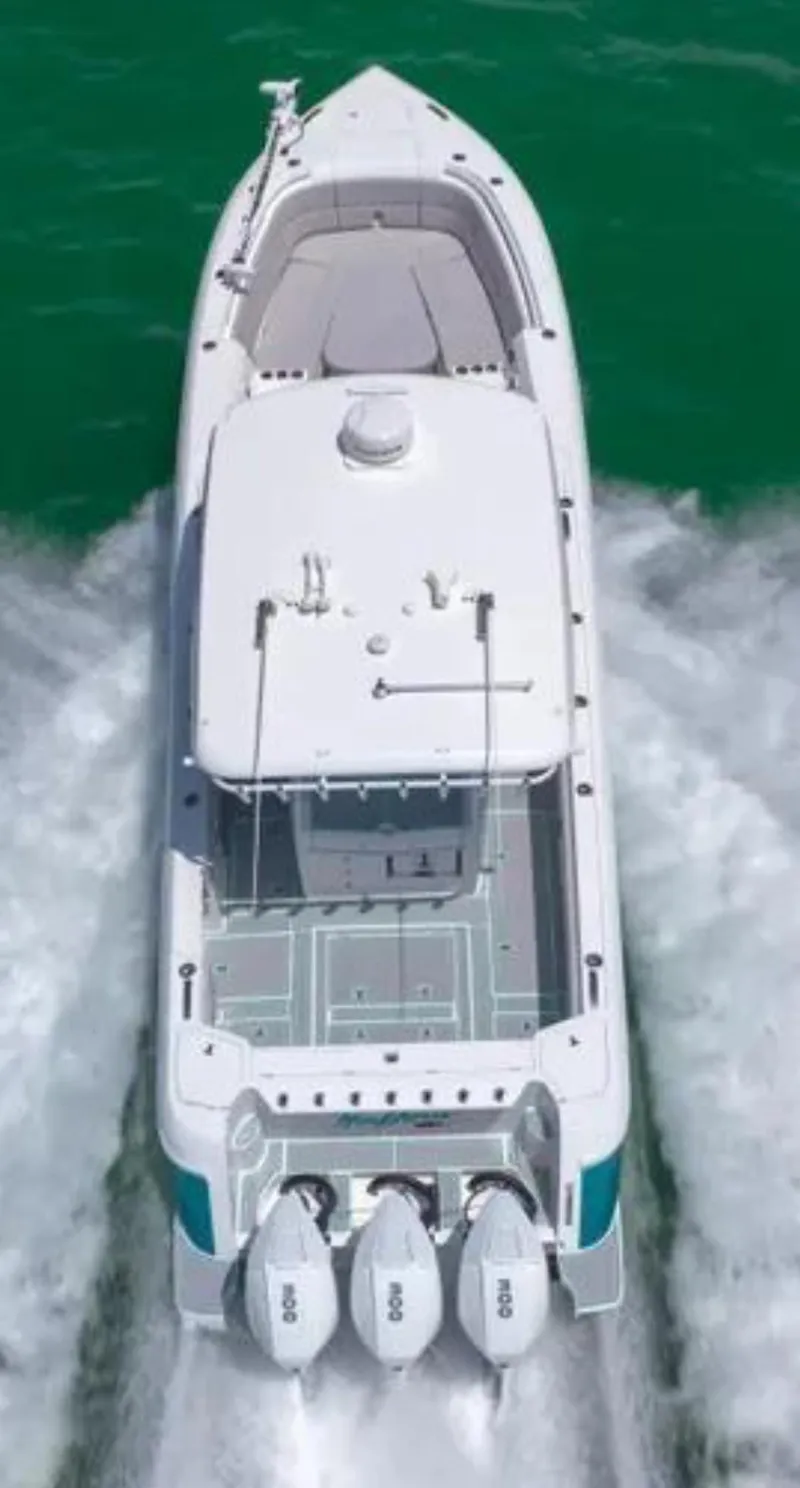 Slide: The Image of 2023 Intrepid 375 boat cruising on water, aerial view, triple outboard engines. - 10