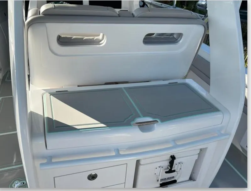 Slide: The Image of 2023 Intrepid 375 boat interior with storage compartment and cushioned seating. - 3