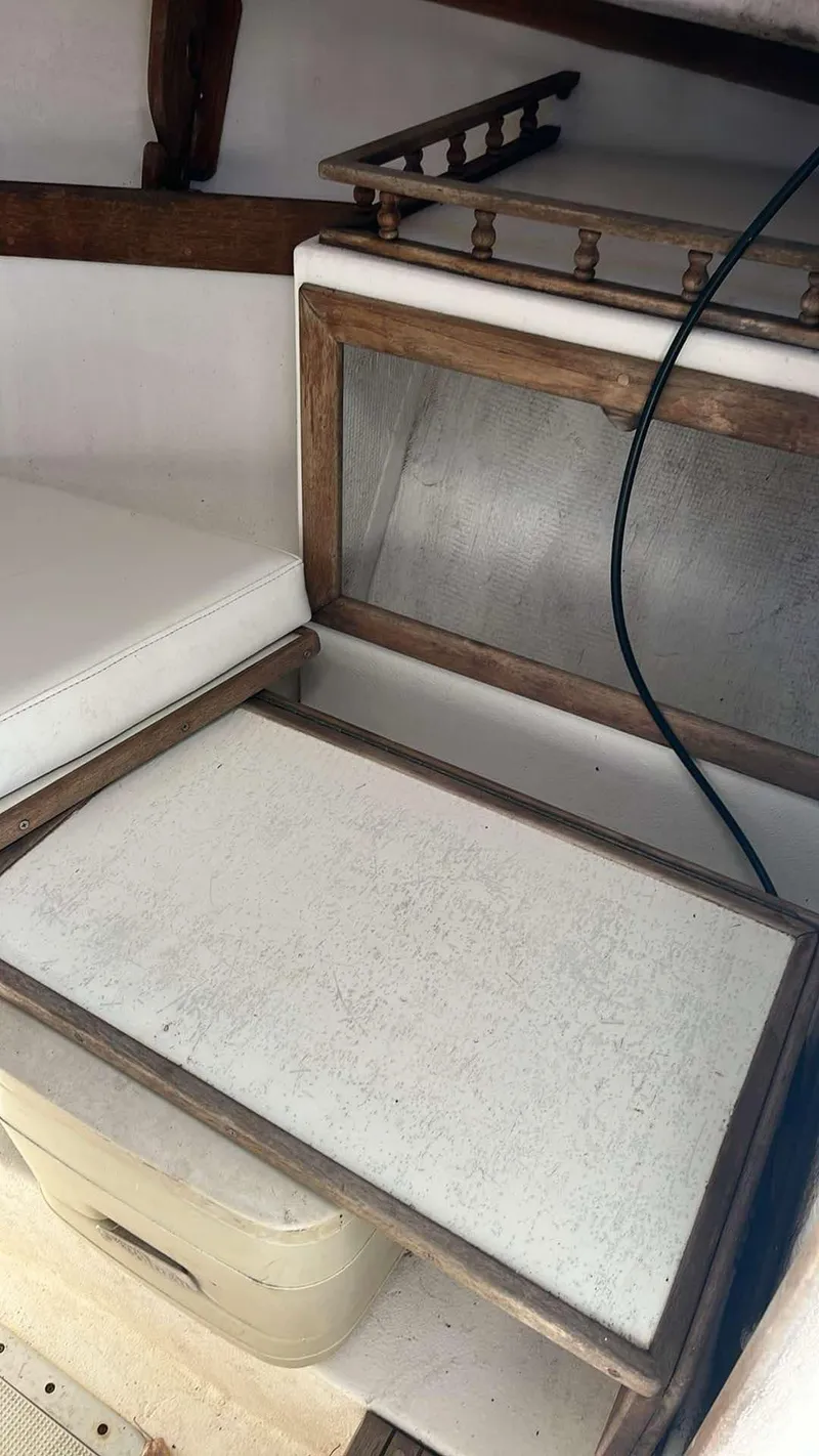 Slide: The Image of 1987 Nauset 249 boat interior with wooden trim and white seating. - 11