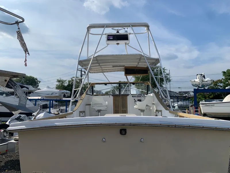 Slide: The Image of 1987 Nauset 249 boat with tower, docked under a clear sky. - 2