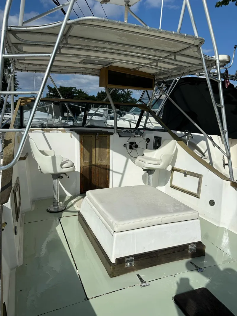 Slide: The Image of 1987 Nauset 249 boat interior with seating and steering wheel under canopy. - 8