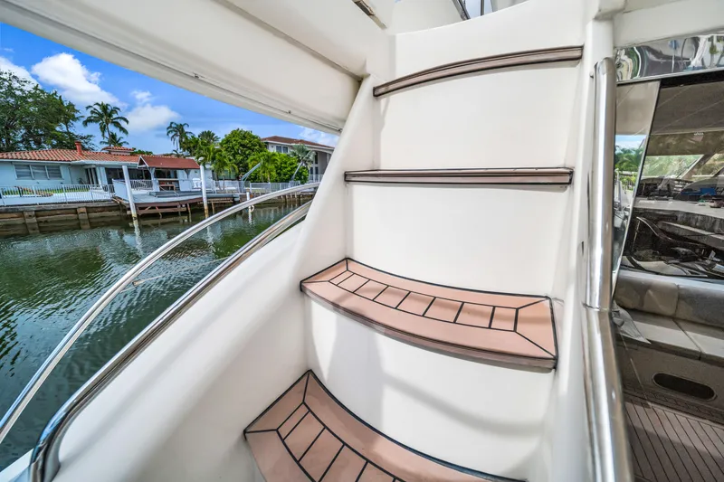 Slide: The Image of Staircase on a 2002 Princess 61 yacht, with waterfront view in the background. - 13