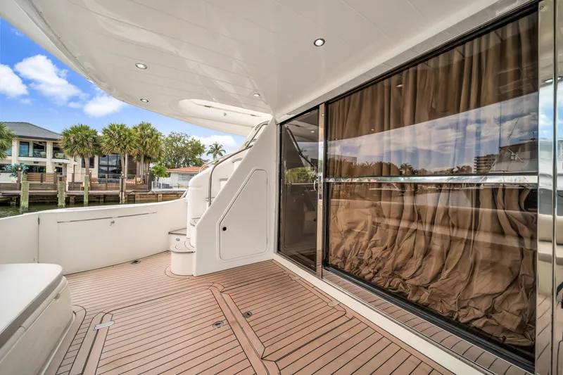 Slide: The Image of Luxury yacht deck with wooden flooring, glass doors, and scenic waterfront view. Princess 61, 2002 model. - 16