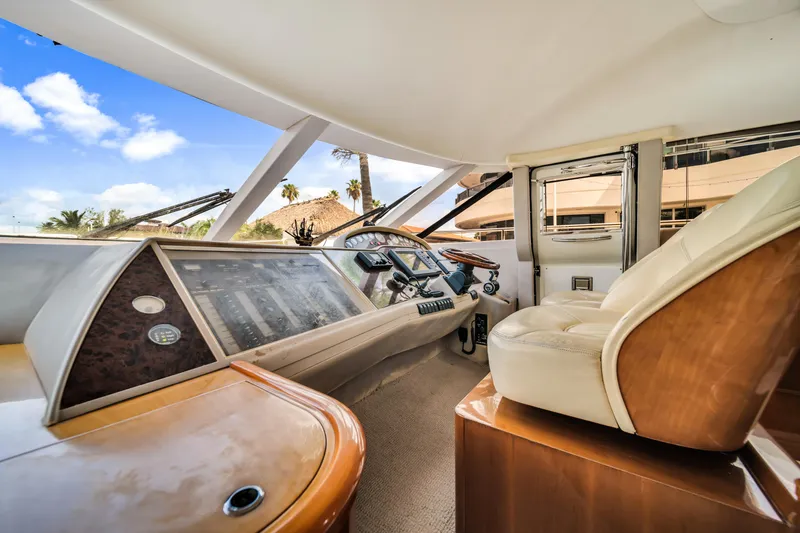 Slide: The Image of Interior view of a 2002 Princess 61 yacht cockpit with luxurious seating and control panel. - 24