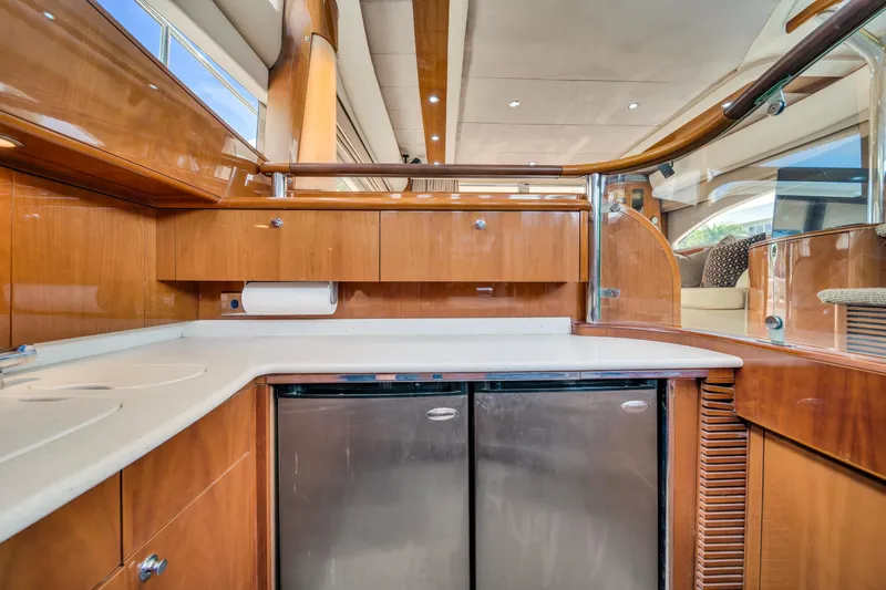Slide: The Image of Luxurious kitchen area in a 2002 Princess 61 yacht with wooden cabinetry and dual refrigerators. - 26