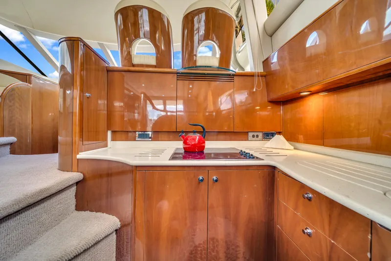 Slide: The Image of Luxurious kitchen interior of a 2002 Princess 61 yacht with wooden cabinetry and modern appliances. - 27